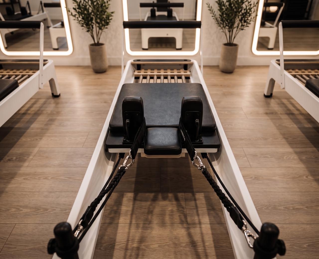 Pilates reformer close-up with class in background